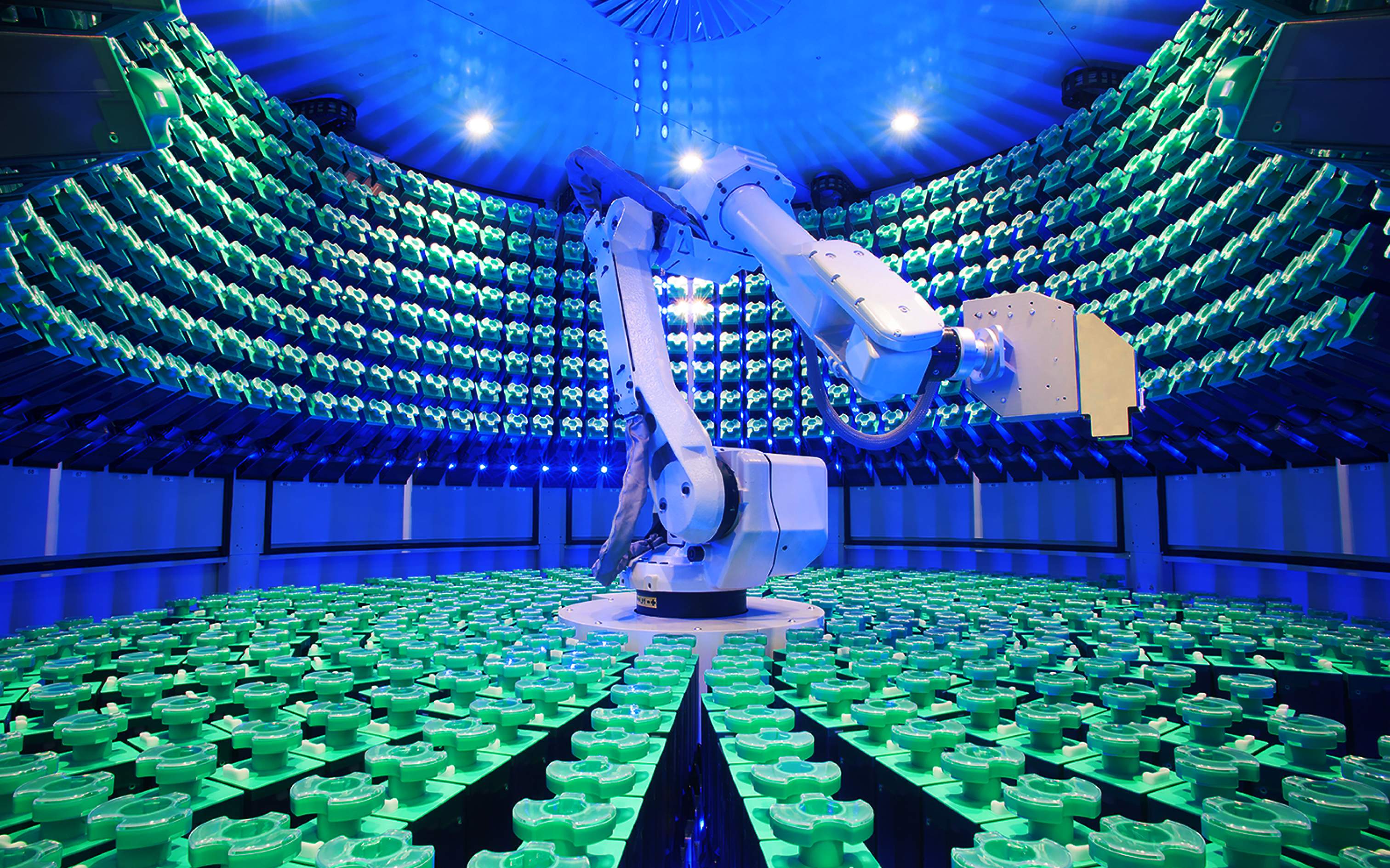 A wide shot of a mechanical arm arranging containers